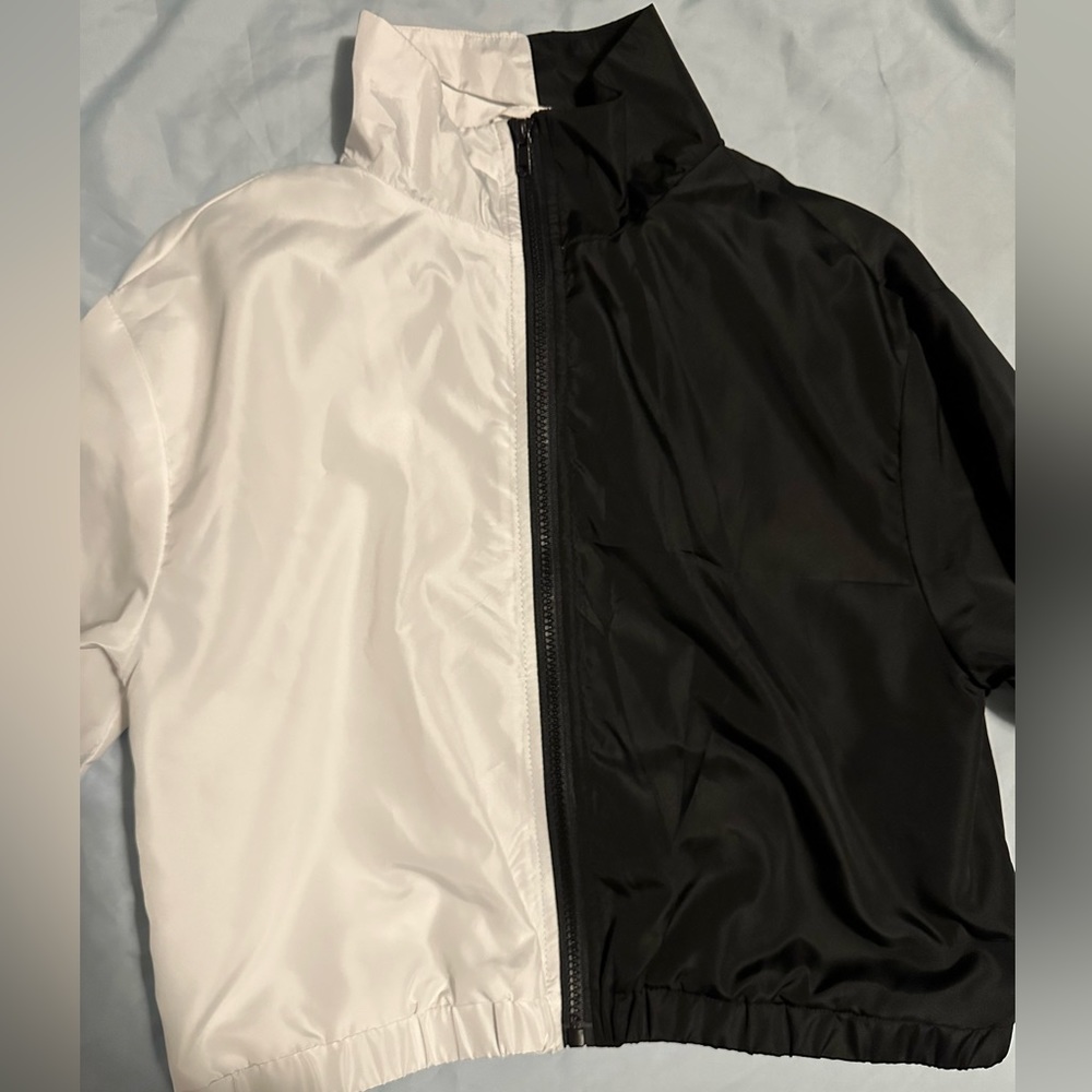 Half black, half white, thin, cropped wind breaker.
